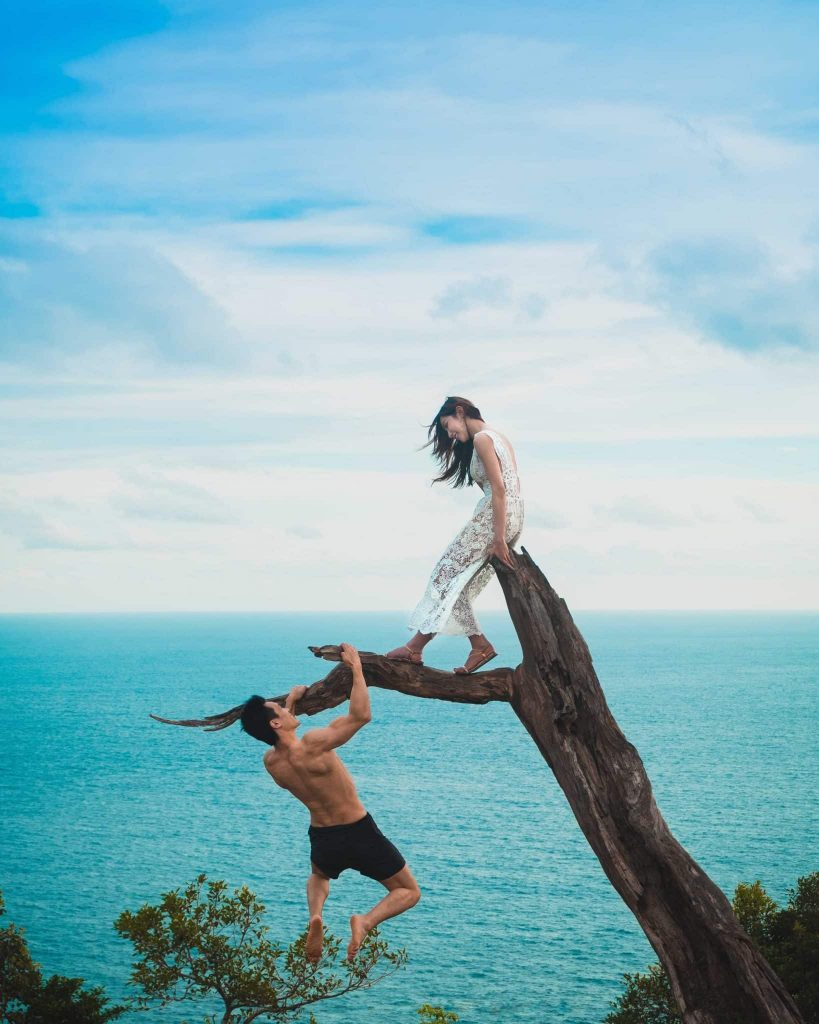 Man hanging from a branch shirtless